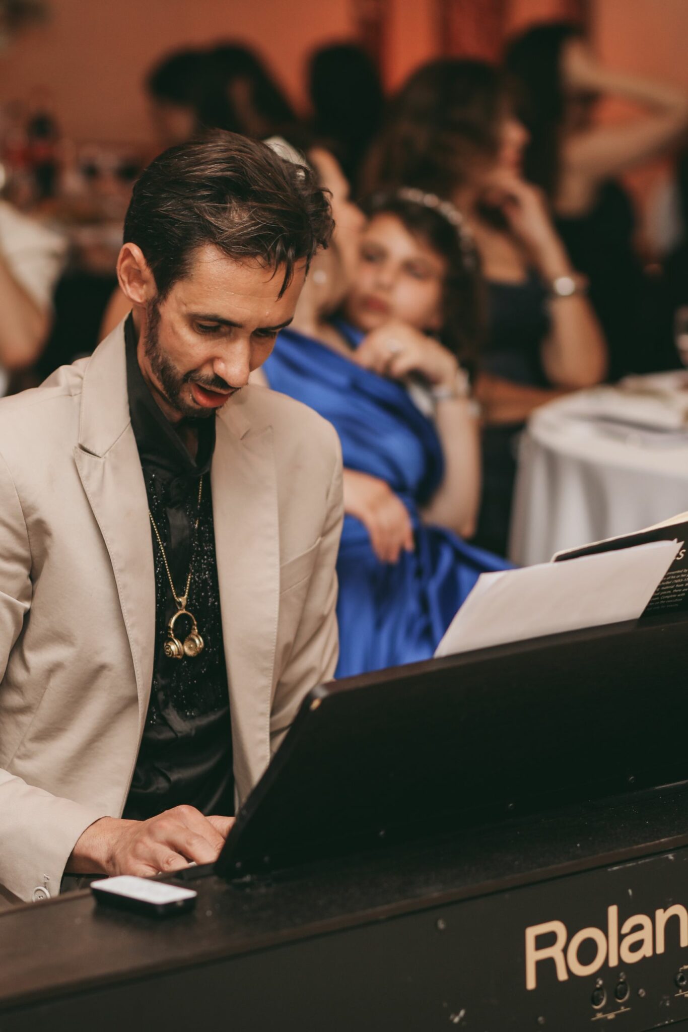 DJ Dadicool en costume beige aux platines clavier Roland animant un mariage mixte en Ile de France