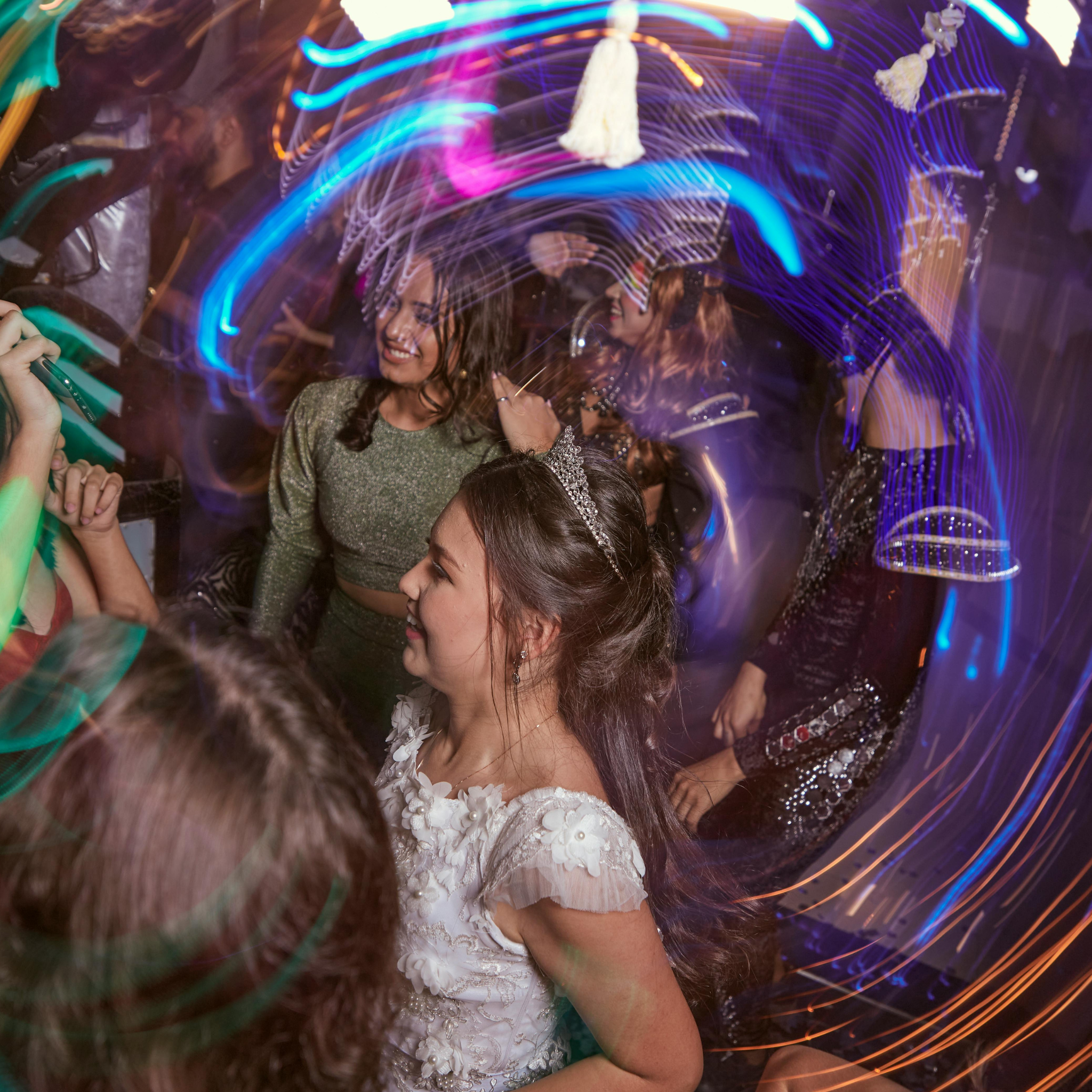 jeune fille en robe blanche avec tiare sur le dancefloor au milieu des jeux de lumiere bleus