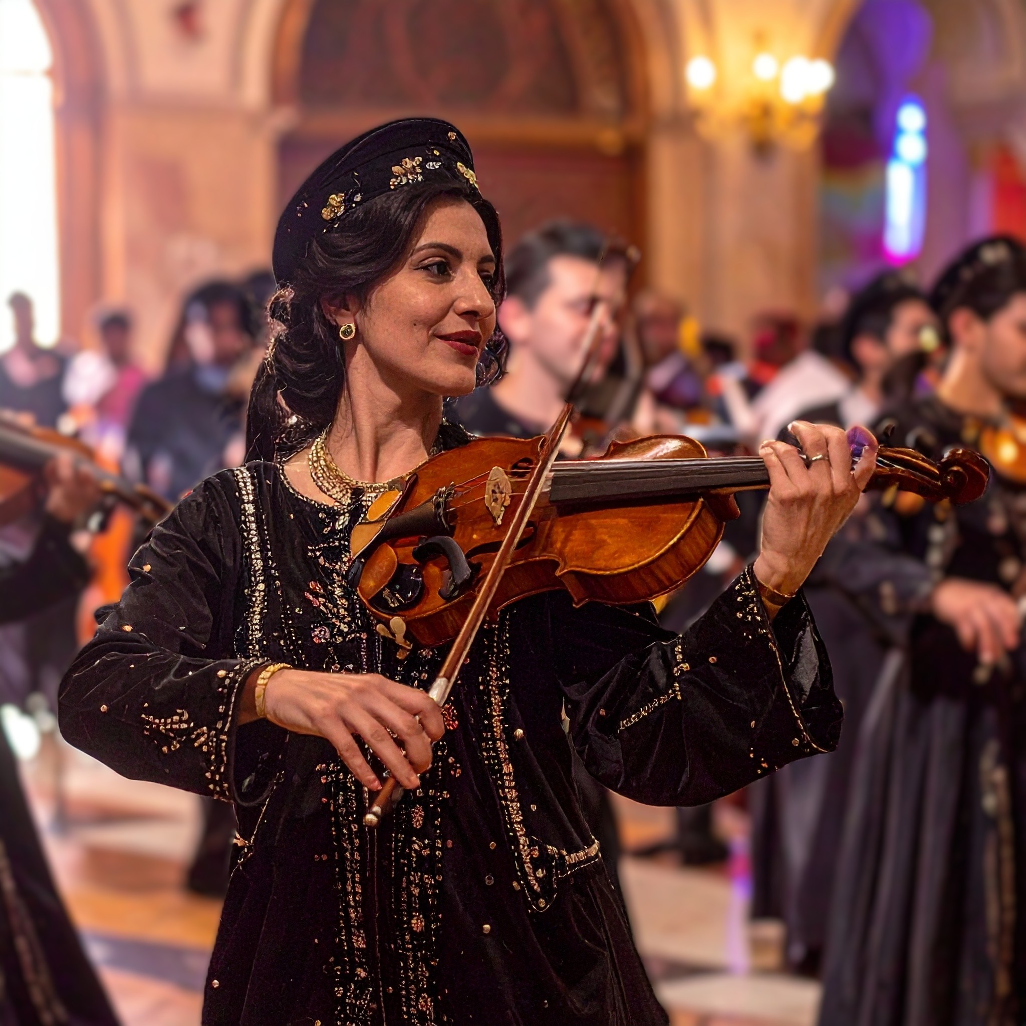 musicienne au violon avec coiffe ornée pendant un mariage mixte ambiance dancefloor