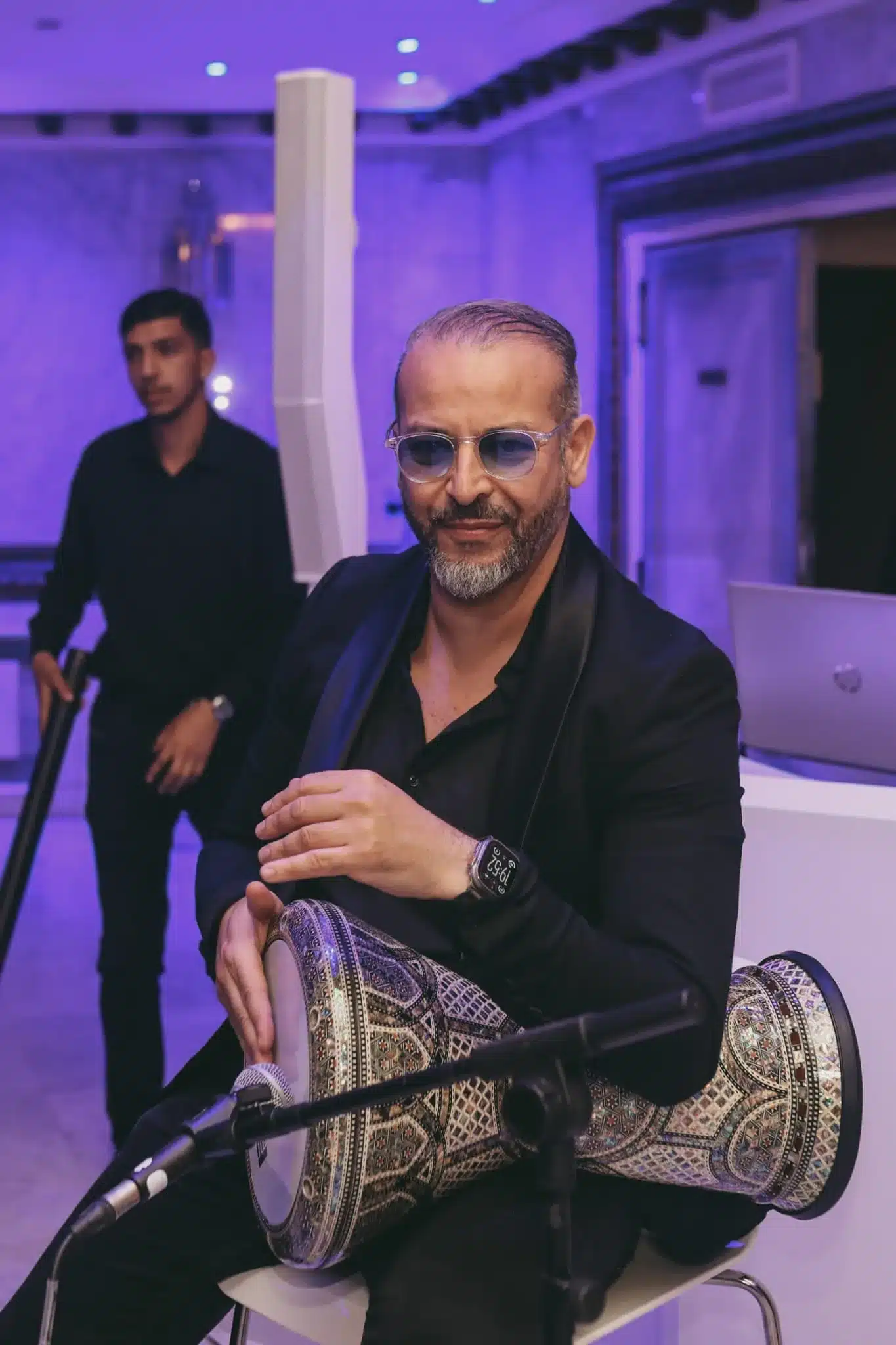 Percussionniste avec derbouka décorée sous lumière violette lors d'un mariage marocain à Paris